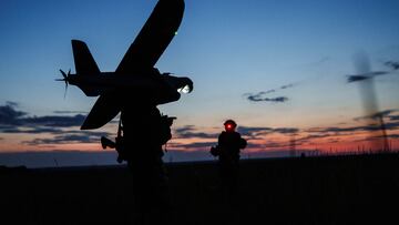 Service members of the 13th Operative Purpose Brigade 'Khartiia' of the National Guard of Ukraine walk in a field to launch a Ukrainian-made Leleka reconnaissance unmanned aerial vehicle a front line, amid Russia's attack on Ukraine, in Kharkiv region, Ukraine July 20, 2025. REUTERS/Serhii Korovainyi