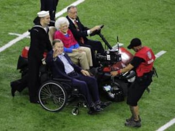 El ex presidente de los EE.UU, George H.W. Bush y su esposa realizaron los honores de llevar la moneda del sorteo de campo.