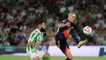 Girona's Spanish midfielder #14 Oriol Romeu fights for the ball with Real Betis' French midfielder #08 Nabil Fekir during the Spanish league football match between Real Betis and Girona FC at the Benito Villamarin stadium in Seville on August 15, 2024. (Photo by CRISTINA QUICLER / AFP)