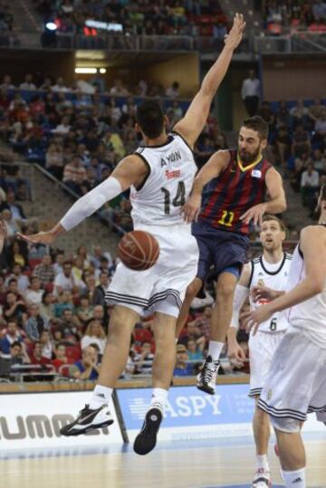El base del F.C. Barcelona Juan Carlos Navarro pasa el balón ante la defensa del pívot mexicano del Real Madrid Gustavo Ayon.