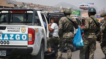 Security forces members detain a woman for being on the street on a Friday, one of the days designated for men after the Peruvian government limited men and women to alternate days for leaving their homes in an attempt to slow the spread of the coronaviru