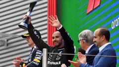 Mercedes' British driver Lewis Hamilton raises his trophy as he celebrates on the podium with Red Bull's Dutch driver Max Verstappen (R) after the Spanish Formula One Grand Prix at the Circuit de Catalunya on June 23, 2024 in Montmelo, on the outskirts of Barcelona. (Photo by Manaure Quintero / AFP)
