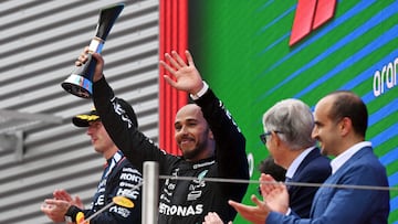 Mercedes' British driver Lewis Hamilton raises his trophy as he celebrates on the podium with Red Bull's Dutch driver Max Verstappen (R) after the Spanish Formula One Grand Prix at the Circuit de Catalunya on June 23, 2024 in Montmelo, on the outskirts of Barcelona. (Photo by Manaure Quintero / AFP)