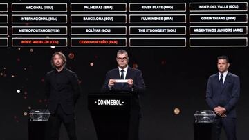 Conmebol's director of competitions and operations Frederico Nantes (C), assistend by ex-footballers Diego Lugano (L) of Uruguay and Ricardo Tavarelli of Paraguay, displays the paper slip of Peru's Sporting Cristal during the draw of the group phase of the Libertadores Cup football tournament, at Conmebol's headquarters in Luque, Paraguay, on March 27, 2023. (Photo by NORBERTO DUARTE / AFP) (Photo by NORBERTO DUARTE/AFP via Getty Images)