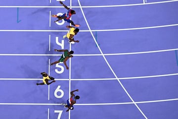 An overview shows US' Noah Lyles crossing the finish line in the men's 100m final of the athletics event at the Paris 2024 Olympic Games at Stade de France in Saint-Denis, north of Paris, on August 4, 2024. (Photo by Jewel SAMAD / AFP)