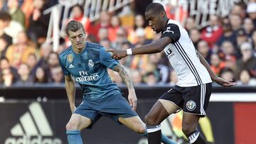 Valencia's French midfielder Geoffrey Kondogbia (R) vies with Real Madrid's German midfielder Toni Kroos during the Spanish league football match between Valencia CF and Real Madrid CF at the Mestalla stadium in Valencia on January 27, 2018. / A