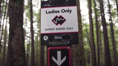 El cartel del sendero de MTB Ladies Only (Vancouver, Canad&aacute;), con el bosque al fondo. 