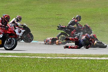 Monster Energy Yamaha MotoGP's French rider Fabio Quartararo (R) and Red Bull KTM Factory's Australian rider Jack Miller (C) fall after a collision during the MotoGP Malaysian Grand Prix at the Sepang International Circuit in Sepang on November 3, 2024. (Photo by MOHD RASFAN / AFP)