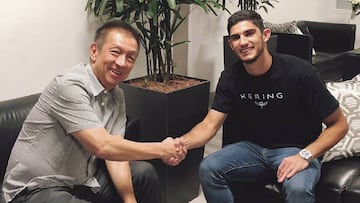 Gonçalo Guedes estrecha la mano de Peter Lim, propietario del Valencia.