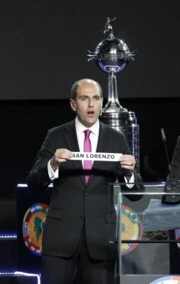 Conmebol General Secretary Sergio Jadue from Chile, holds up a ballot with Argentina's San Lorenzo for Group 2, during the Copa Libertadores' draw ceremony in Luque, Paraguay, Tuesday, Dic. 2, 2014. (AP Photo/Jorge Saenz)