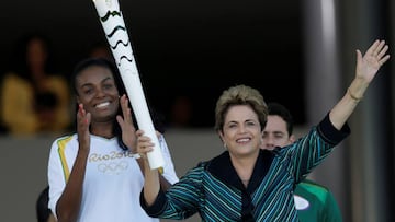 Brazil&#039;s President Dilma Rousseff (R) waves after lighting a cauldron with the Olympic Flame next to Fabiana Claudino, captain of the Brazilian volleyball team, during the Olympic Flame torch relay at Planalto Palace in Brasilia, Brazil, May 3, 2016. REUTERS/Ueslei Marcelino