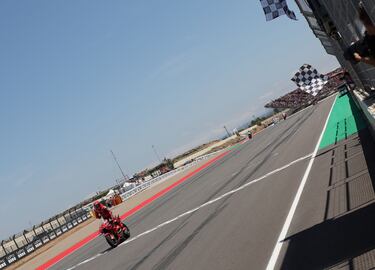 El piloto español de Ducati, Marc Márquez, pasando la bandera de cuadros en primera posición en el circuito de Motorland correspondiente al Gran Premio de Aragón de MotoGP.