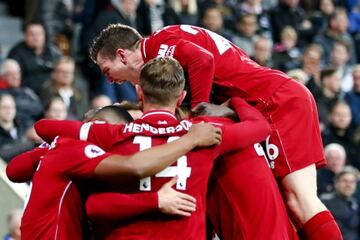 Divock Origi celebrates under a pile of Liverpool teammates after late winner over Newcastle United.