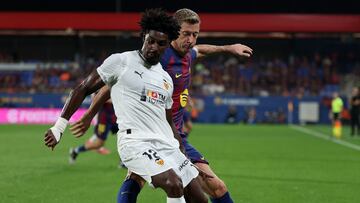 Barcelona's Polish forward #09 Robert Lewandowski fights for the ball with Valencia's Portuguese defender #12 Thierry Correia during the Spanish league football match between FC Barcelona and Valencia CF at Johan Cruyff Stadium in Barcelona, on September 14, 2025. (Photo by Lluis GENE / AFP)