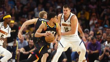 Phoenix Suns guard Devin Booker (1) moves the ball against Denver Nuggets center Nikola Jokic (15) in the second half during game four of the 2023 NBA playoffs at Footprint Center.