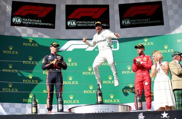 Lewis Hamilton celebra la victoria de carrera en el podio con Max Verstappen y Sebastian Vettel. 