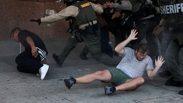 Manifestantes en el suelo durante un enfrentamiento con agentes del orden en una protesta contra las redadas del ICE en Los Ángeles, California.