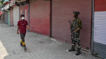 13 July 2020, India, Kashmir: A man wears a protective face mask walks past a paramilitary trooper standing on guard during a lockdown re-imposed to prevent the spread of coronavirus. Photo: Saqib Majeed/SOPA Images via ZUMA Wire/dpa
13/07/2020 ONLY
