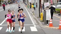 FILE PHOTO: A spectator raises a paper sign reading &#039;It is impossible to hold the Olympics, face up to reality&#039; along the race route during the half-marathon as part of Hokkaido-Sapporo Marathon Festival 2021, a testing event for the Tokyo 2020 