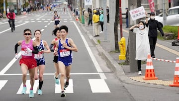 FILE PHOTO: A spectator raises a paper sign reading &#039;It is impossible to hold the Olympics, face up to reality&#039; along the race route during the half-marathon as part of Hokkaido-Sapporo Marathon Festival 2021, a testing event for the Tokyo 2020 