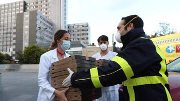 Un empleado de correos reparte pizzas entre el personal sanitario de los hospitales de Madrid durante otra jornada m&aacute;s marcada por la pandemia de coronavirus.