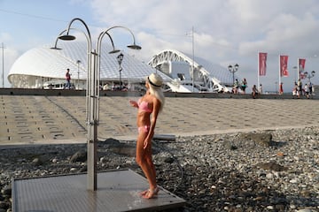 Al lado del estadio de Sochi, en la playa pública, una aficionada toma un regaderazo.