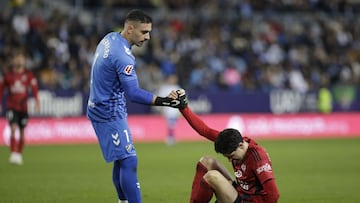 Alfonso Herrero ayuda a levantarse al rojillo Carlos Fernández.