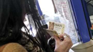 Una mujer compra varios d&eacute;cimos en una administraci&oacute;n de Loter&iacute;a de Valencia. EFE/Manuel Bruque/Archivo