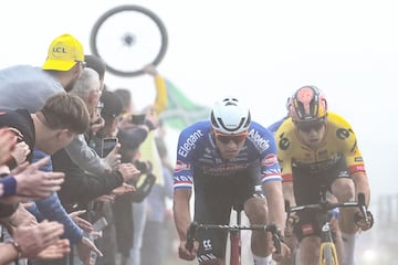 Grupos de aficionados animan al ciclista neerlandés del Alpecin-Deceuninck, Mathieu Van Der Poel, y al belga del Jumbo-Visma, Wout Van Aert , rodeados de polvo en un sector de la carrera.