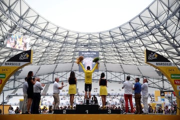 Froome subido en el pódium con el maillot amarillo.
