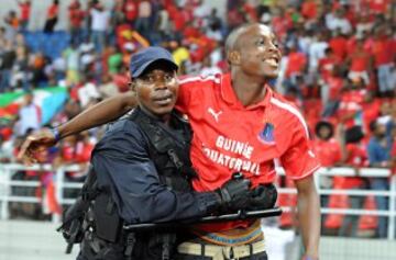 Un policía retiene a un seguidor de Guinea Ecuatorial después de lograr la victoria sobre Senegal en la Copa de África en el estadio de Bata el 25 de enero de 2012