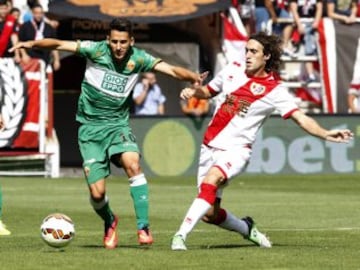 El centrocampista del Rayo Vallecano, Raúl Baena (d), y el delantero del Elche, Ferrán Corominas (i), disputan el balón durante el partido de la tercera jornada de Liga de Primera División 