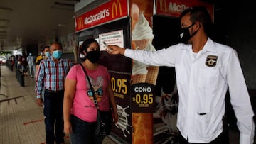 PA1001. CIUDAD DE PANAMÁ (PANAMÁ) 1-6-2020.- Un guardia de seguridad toma la temperatura a una mujer al momento de entrar a un supermercado en la capital, durante la flexibilización de la cuarentena, impuesta para frenar la propagación del COVID-19. Las restricciones de movilidad por género y solo por dos horas diarias que estaban vigentes desde el pasado 25 de marzo han sido suspendidas desde este lunes y todos los adultos pueden salir entre las 5 de la mañana y las 7 de la noche, hora a partir de la cual comenzará a regir un toque de queda nocturno y también se autorizó la apertura de industrias y el reinicio de lo proyectos de construcción pública. EFE/Bienvenido Velasco