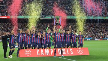 Busquets levanta la copa mientras el resto de compañeros de equipo y el técnico lo celebran.