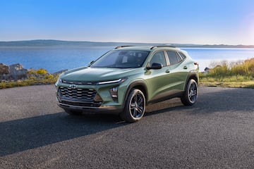 3/4 view of Chevrolet Trax ACTIV in Cacti Green parked on a road in front of a lake. Pre-production model shown. Actual production model may vary. Available in spring 2023. Cacti Green exterior color late availability.