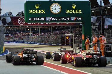 El piloto belga de McLaren, Stoffel Vandoorne, el piloto finlandés Valtteri Bottas y el piloto alemán de Ferrari, Sebastian Vettel, se preparan para salir del pit lane.