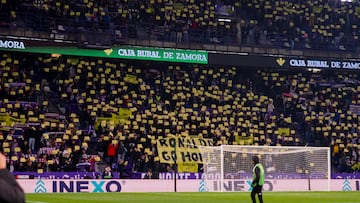 VALLADOLID. 30/11/2024. - Aficionados despliegan una pancarta y muestran cartulinas en las gradas durante el partido de LaLiga entre el Real Valladolid y el Atlético de Madrid, este sábado en el estadio José Zorrilla. EFE/R. GARCIA.