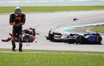 Brad Binder comprueba sus protectores del mono, chequeando que no tenga heridas graves.