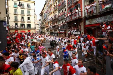 Participantes corren delante de los toros durante el primer encierro de los Sanfermines en Pamplona.