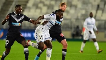 Strasbourg's French forward Stephane Bahoken (C) fights for the ball with Bordeaux's players during the French Ligue 1 football match between Bordeaux and Strasbourg at The Matmut Atlantique Stadium in Bordeaux, southwestern France on December 8, 2017. / AFP PHOTO / NICOLAS TUCAT