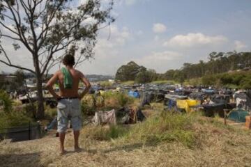 Un integrante del Movimiento de los Trabajadores Sin Techo (MTST) observa un área que fue ocupada el pasado sábado situada a unos 4 kilómetros del estadio Arena Corinthians, una de las doce sedes del Mundial Brasil 2014 y que recibirá seis partidos del evento deportivo, entre ellos el inaugural del 12 de junio. De acuerdo con el movimiento, las familias que ocuparon el terreno, abandonado desde hace más de 20 años, vivían en áreas "de riesgo", "en favelas o sin condiciones para pagar el alquiler por culpa de la especulación inmobiliaria en la región, resultado de la construcción del estadio de apertura del Mundial".