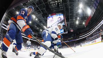 Mathew Barzal #13 of the New York Islanders and Erik Cernak #81 of the Tampa Bay Lightning battle for the puck