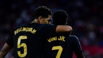 Real Madrid's English midfielder #5 Jude Bellingham hugs Real Madrid's Brazilian forward #07 Vinicius Junior during the Spanish league football match between Sevilla FC and Real Madrid CF at the Ramon Sanchez Pizjuan stadium in Seville on October 21, 2023. (Photo by CRISTINA QUICLER / AFP)