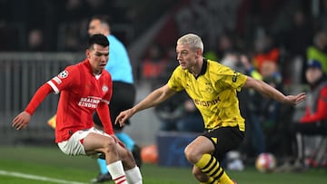 PSV's Mexican forward #27 Hirving Lozano and Dortmund's Norwegian defender #26 Julian Ryerson fight for the ball during the UEFA Champions League round of 16, first leg football match between against PSV Eindhoven and Borussia Dortmund at the The Philips Stadium, in Ei7dhoven on February 20, 2024. (Photo by JOHN THYS / AFP)