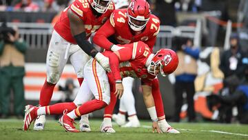 CLEVELAND, OHIO - DECEMBER 15: Trey Smith #65 and Jawaan Taylor #74 of the Kansas City Chiefs help up quarterback Patrick Mahomes #15 after a hit during the third quarter against the Cleveland Browns at Huntington Bank Field on December 15, 2024 in Cleveland, Ohio. Nick Cammett/Getty Images/AFP (Photo by Nick Cammett / GETTY IMAGES NORTH AMERICA / Getty Images via AFP)