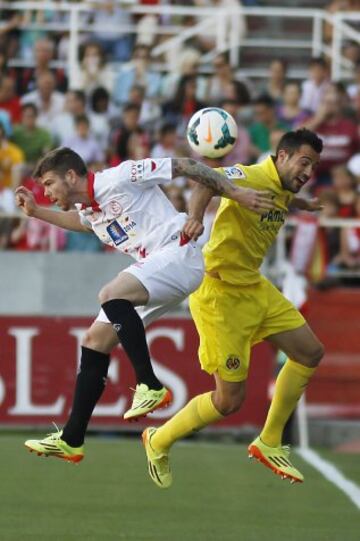 El defensa del Sevilla Alberto Moreno (i) salta a cabeza con el defensa del Villarreal Mario Gaspar (d), durante el partido de la trigésimo sexta jornada de Liga, disputado hoy en el estadio Ramón Sánchez Pizjuán.