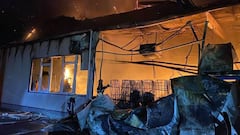 La f&aacute;brica de esqu&iacute;s de Fischer en Ucrania, en llamas, con un bombero intentando apagar el fuego. 