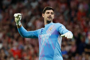 El portero del Real Madrid Thibaut Courtois se deshace de uno de los mecheros lanzados desde la grada.