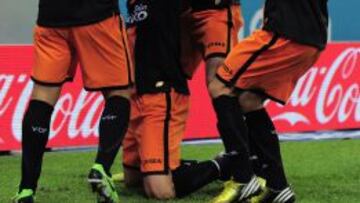 Roberto Soldado, delantero del Valencia, celebra un gol junto con sus compañeros de equipo.