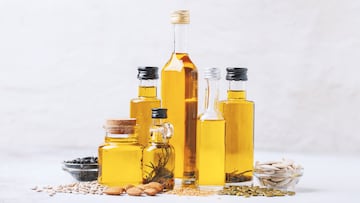Various vegetable and nut oil in bottles on a bright background.